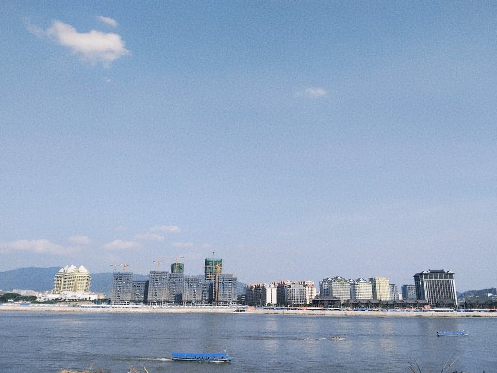 The Golden Triangle where the Mekong River forms the borders of Thailand, Laos, and Myanmar, with a view of the Golden Triangle Special Economic Zone and King Roman Casino in Laos.