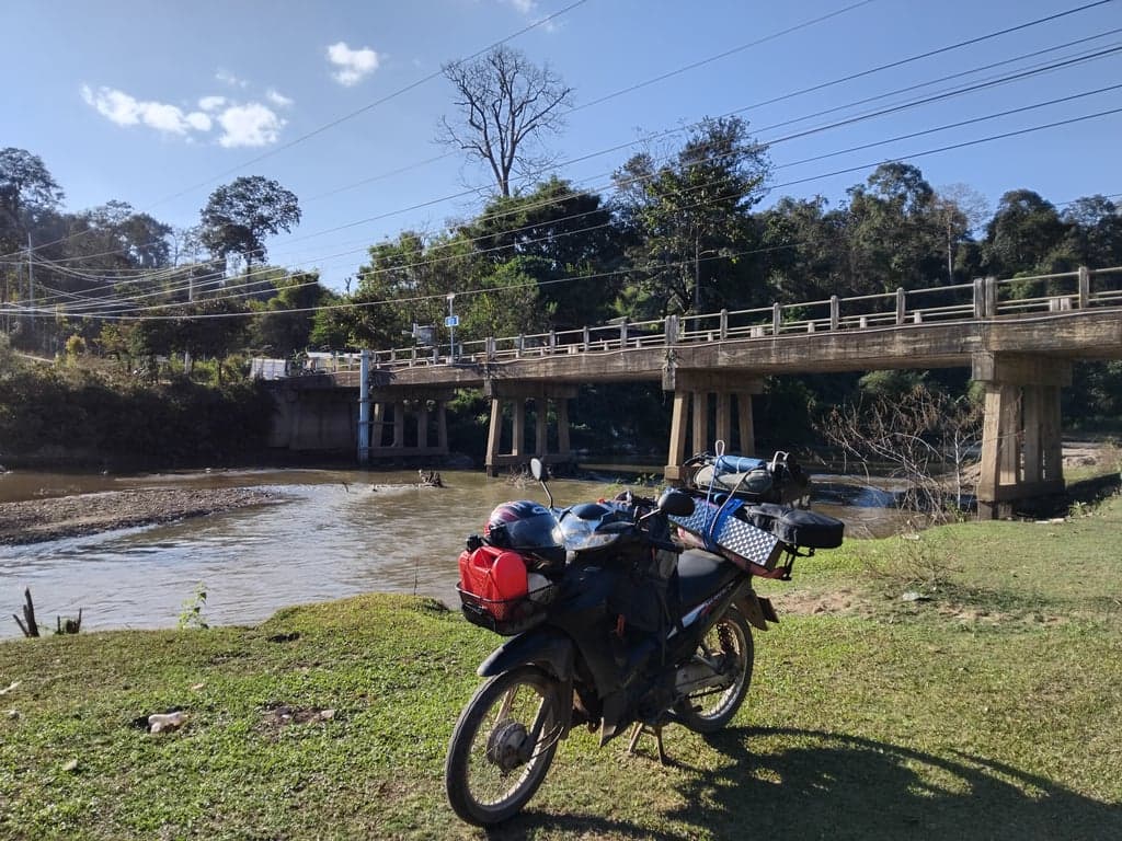 Kong River flowing through the quiet village of Mueang Kong, Chiangdao, surrounded by mountains and rice fields.